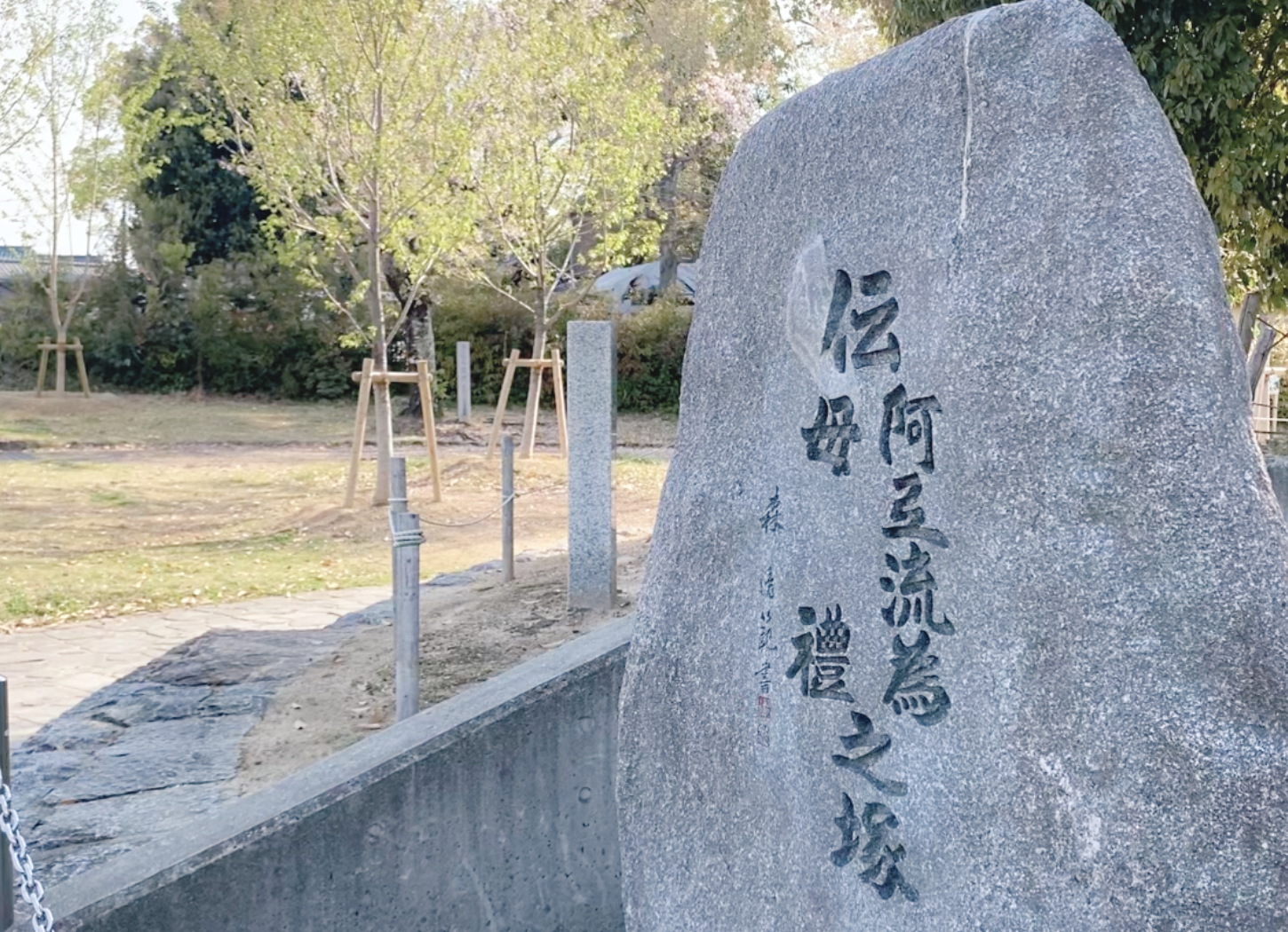 枚方市・牧野公園にある塚の手前に立つ大きな石碑。『伝 アテレイ モレ 之塚』の文字が刻まれている。