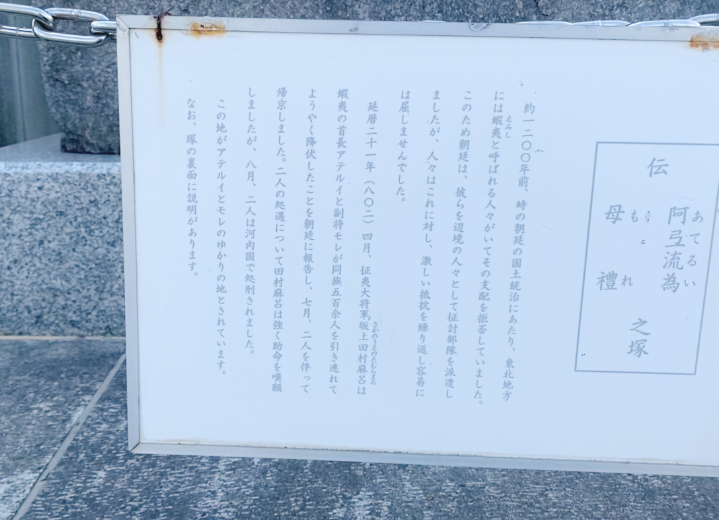 枚方市・牧野公園の大きな石碑の前に設置されたプレート。征夷大将軍・坂上田村麻呂と蝦夷のアテルイ、モレに関する解説が記されている。