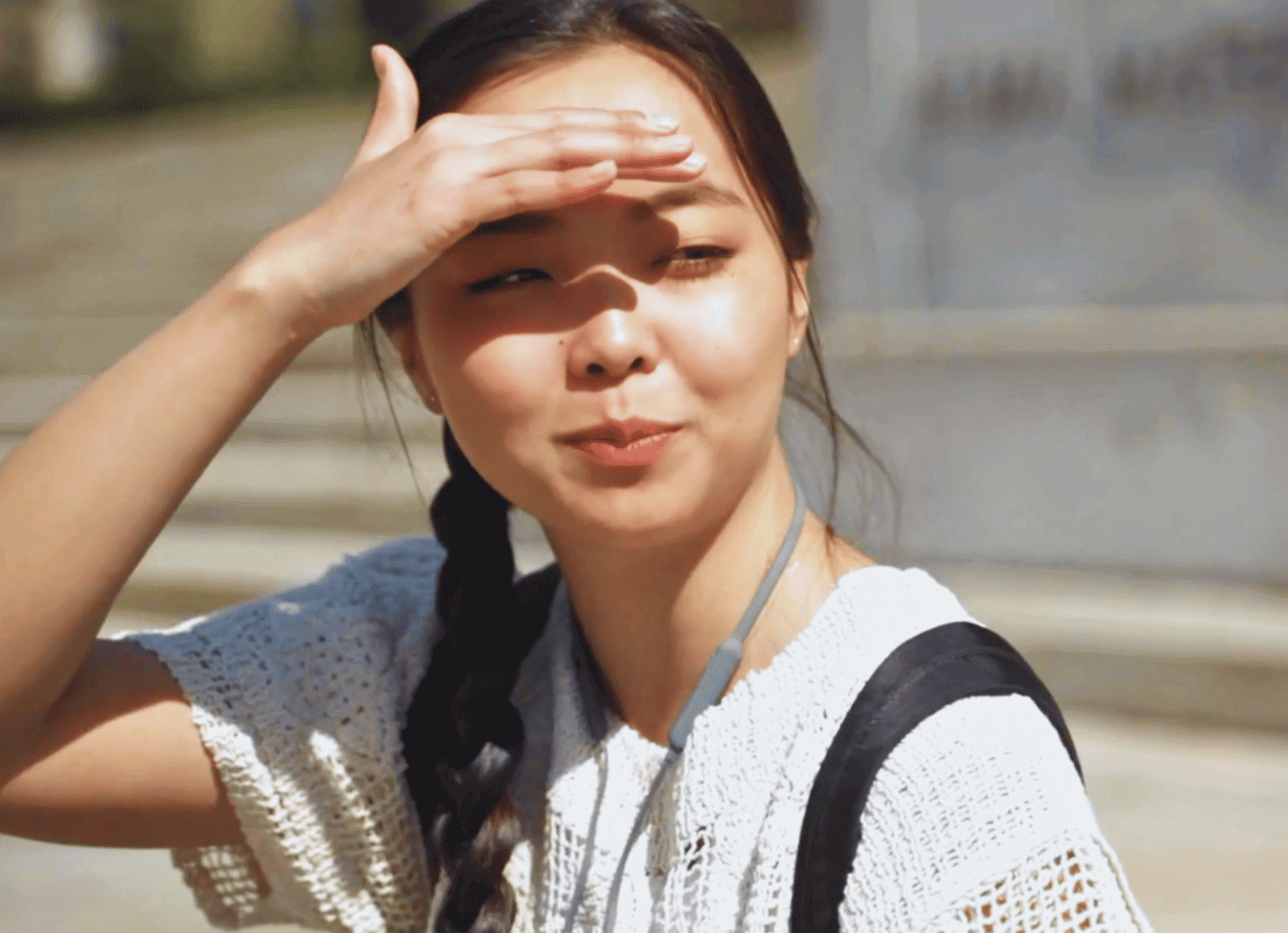 道路に立つ女子が、隣の人物を笑顔で見ている様子。