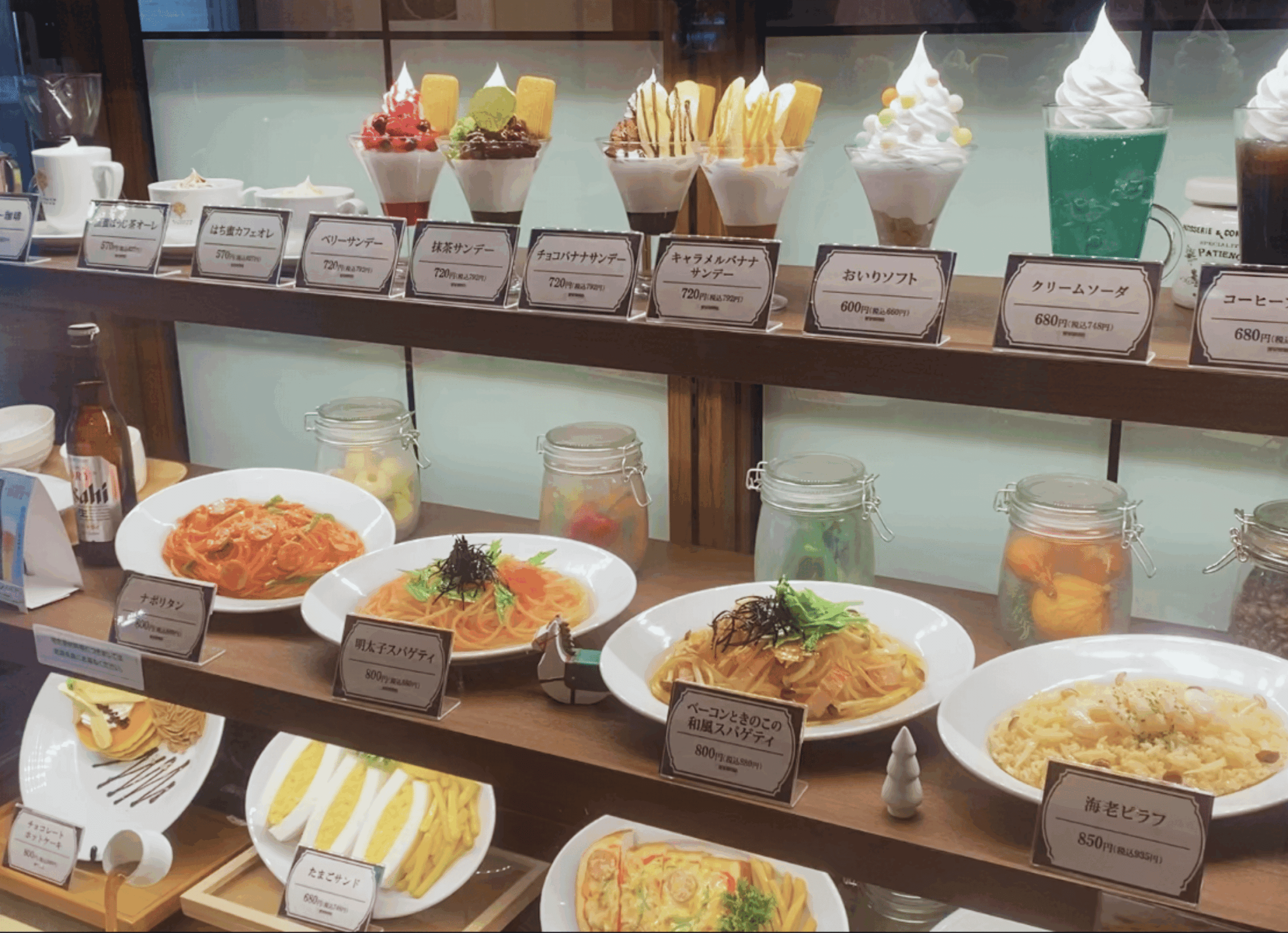枚方市駅構内にある喫茶店「蜜家珈琲店 枚方店」。店頭にはパスタやサンドイッチ、クリームソーダなどの食品サンプルが並び、昔ながらの喫茶店らしい雰囲気を感じさせる。