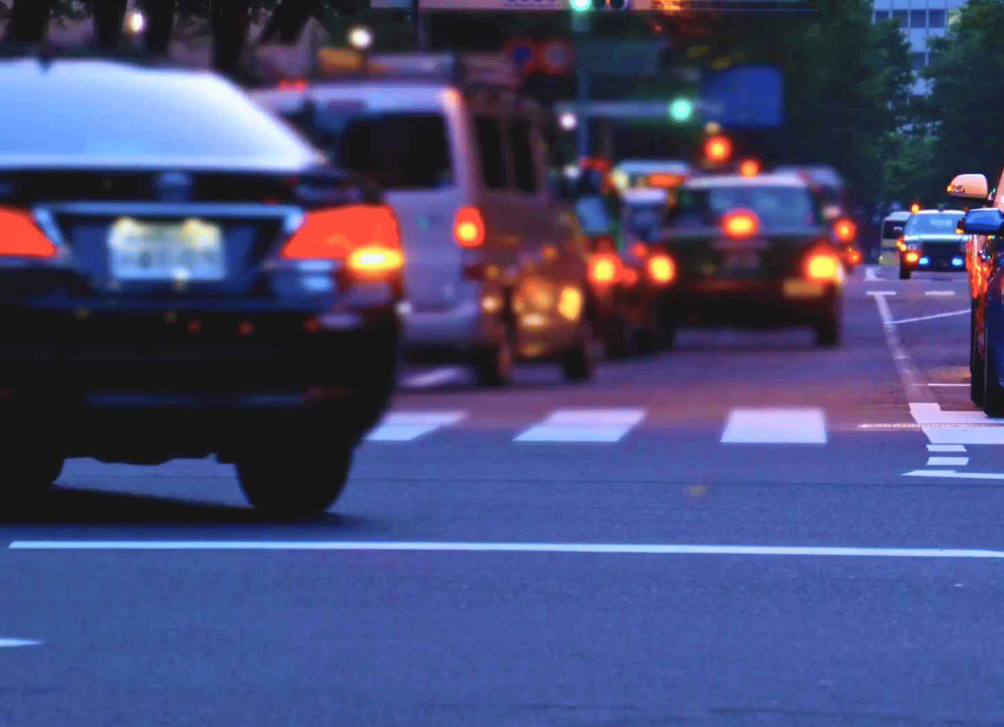 夕暮れの車道を、多くの車が走っている様子。