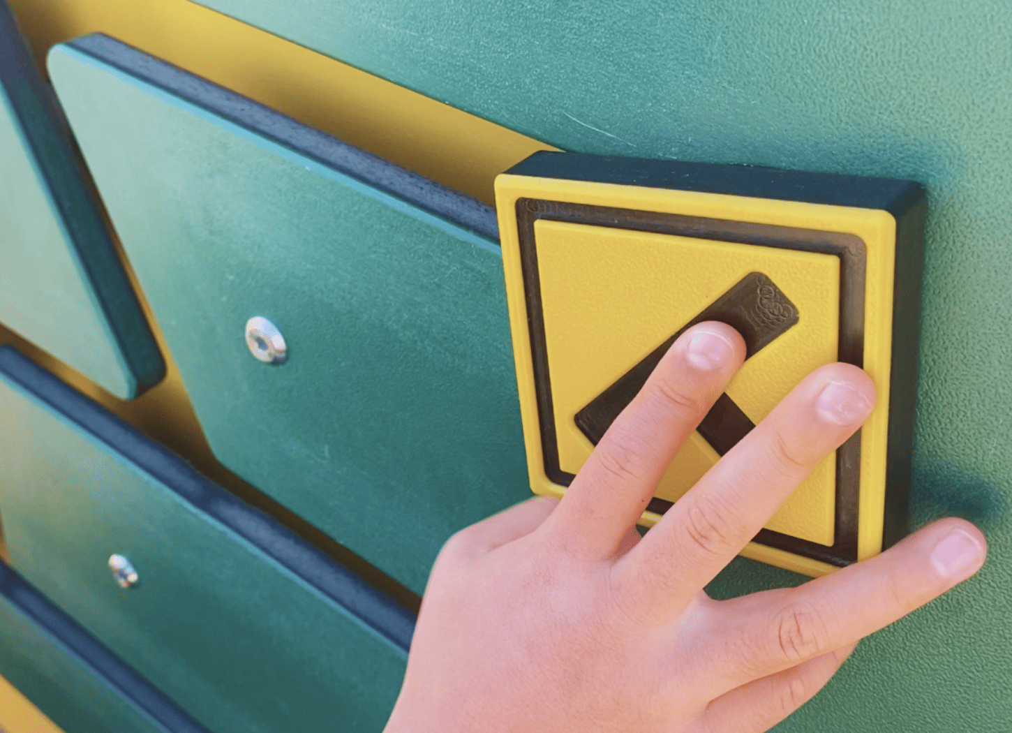 枚方市・牧野車塚古墳のブルドーザー遊具で遊ぶ子どもの手。道路標識のおもちゃを溝に沿って動かす