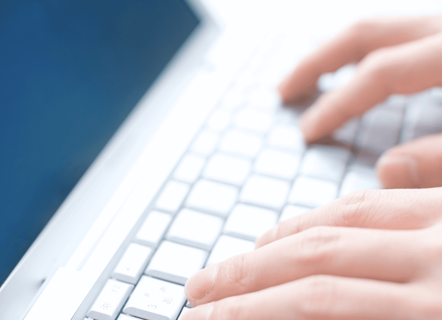 ノートパソコンのキーボードに入力する女性の手元のアップ