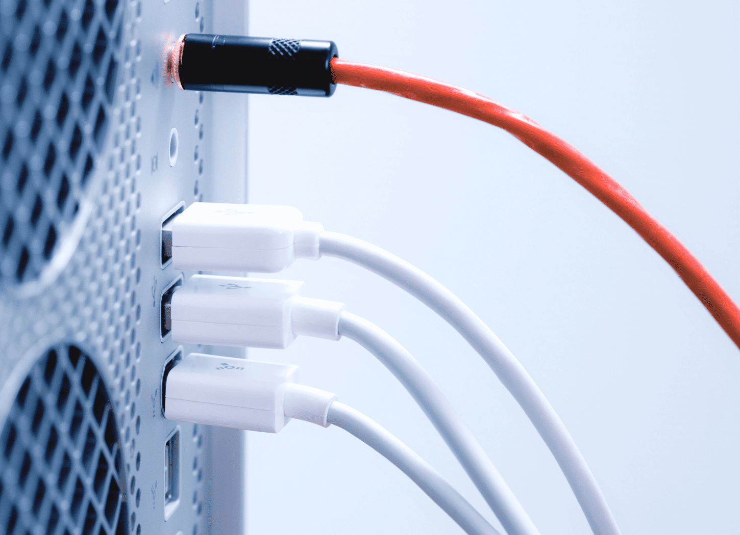 パソコンの裏側。赤いコードが一本、その下に白いコードが三本伸びている配線の様子。