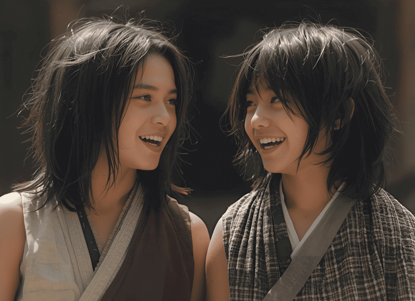 袖のない着物に長い髪、日に焼けた二人の少年——アテルイとモレの幼少期。互いに顔を見て笑い合う、まだあどけない姿。