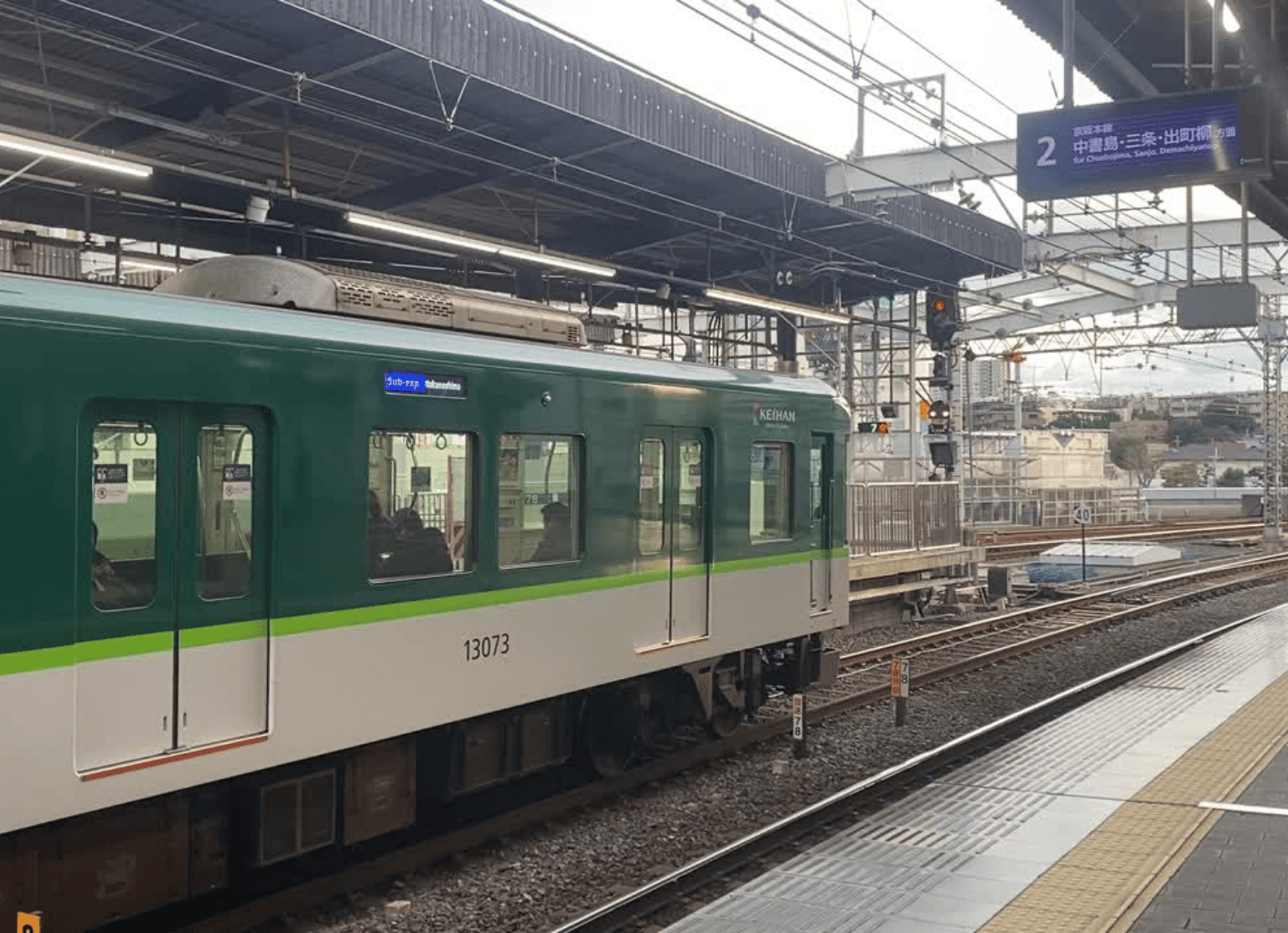枚方市駅に停車する京阪電車。緑と白の車両が牧野方面へ向かう前の様子をホームから撮影