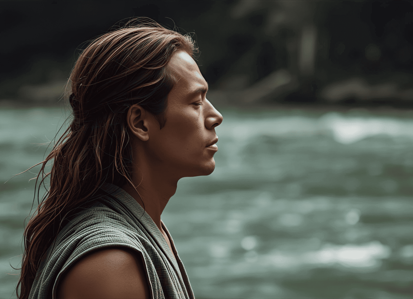 河原で目を閉じ、横顔を見せる男。袖のない着物に長い髪、日に焼けた肌。処刑される直前のモレの緊張と覚悟を表現。