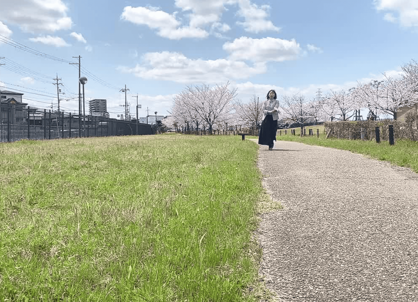 渚水みらいセンターの小道を歩く社会事業開発ACTION代表の堀寛未。木々に囲まれ、鳥のさえずりが響く穏やかな風景