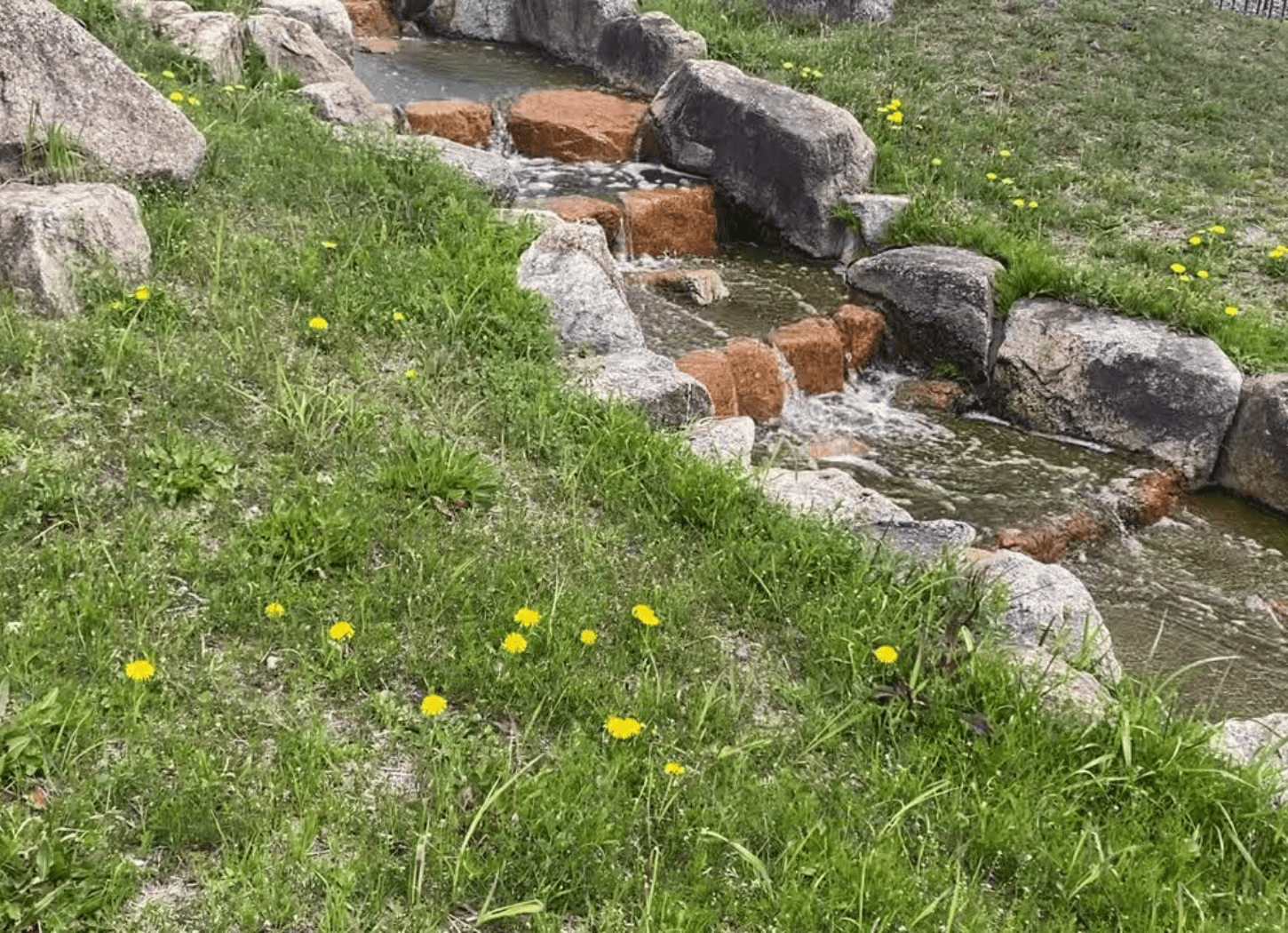 渚水みらいセンターを流れる小川。石の段差を水が飛沫を上げながら穏やかに流れている