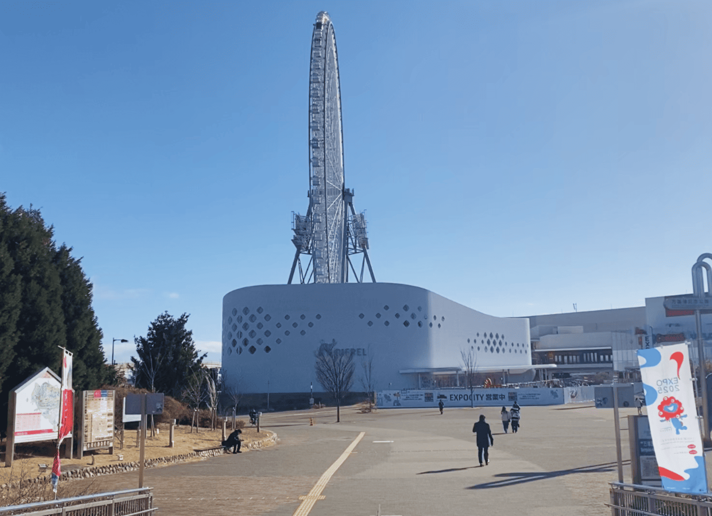 遠くから見たニフレルの建物。白い巨大観覧車とミャクミャクののぼりも確認できる