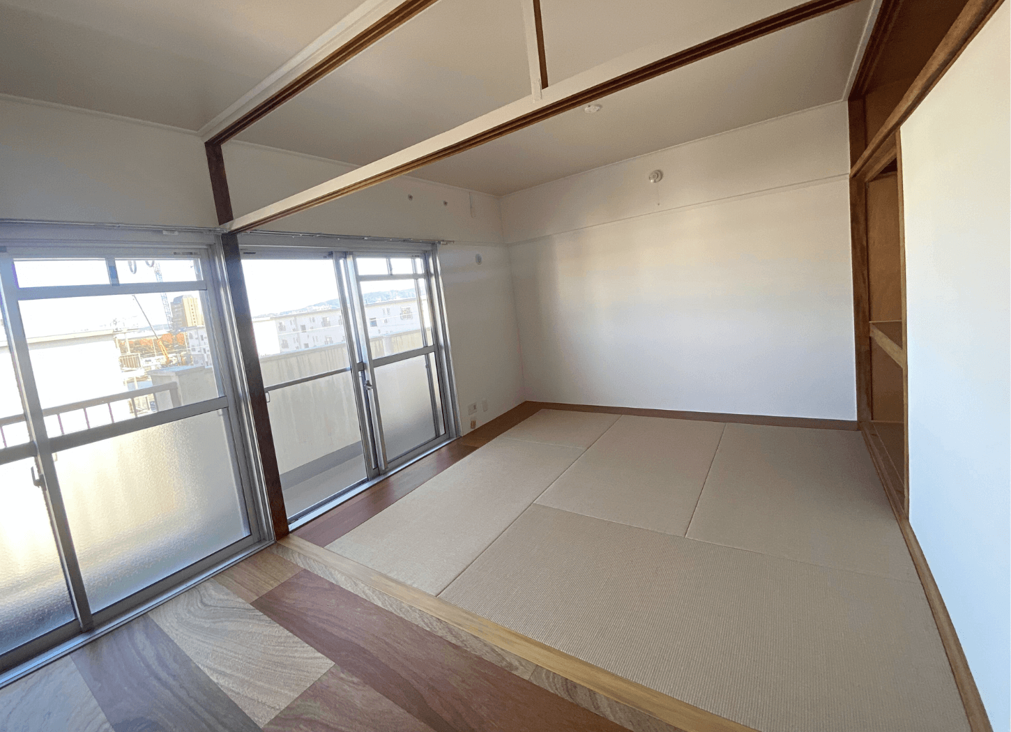 MUJI×URのパーツを取り入れた住戸の室内。和室の畳と、窓の向こうにベランダが見える様子を撮影した写真