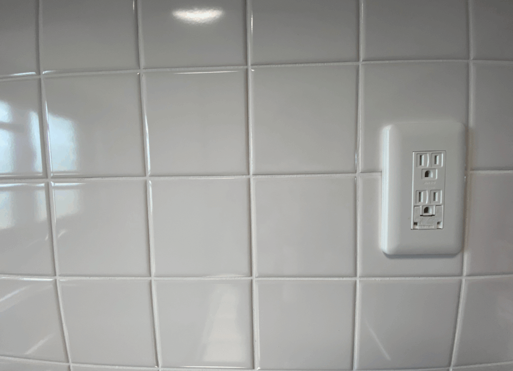 MUJI×UR PARTS ROOMのキッチン。白いタイルの壁とコンセントがあり、広々とした使いやすい空間