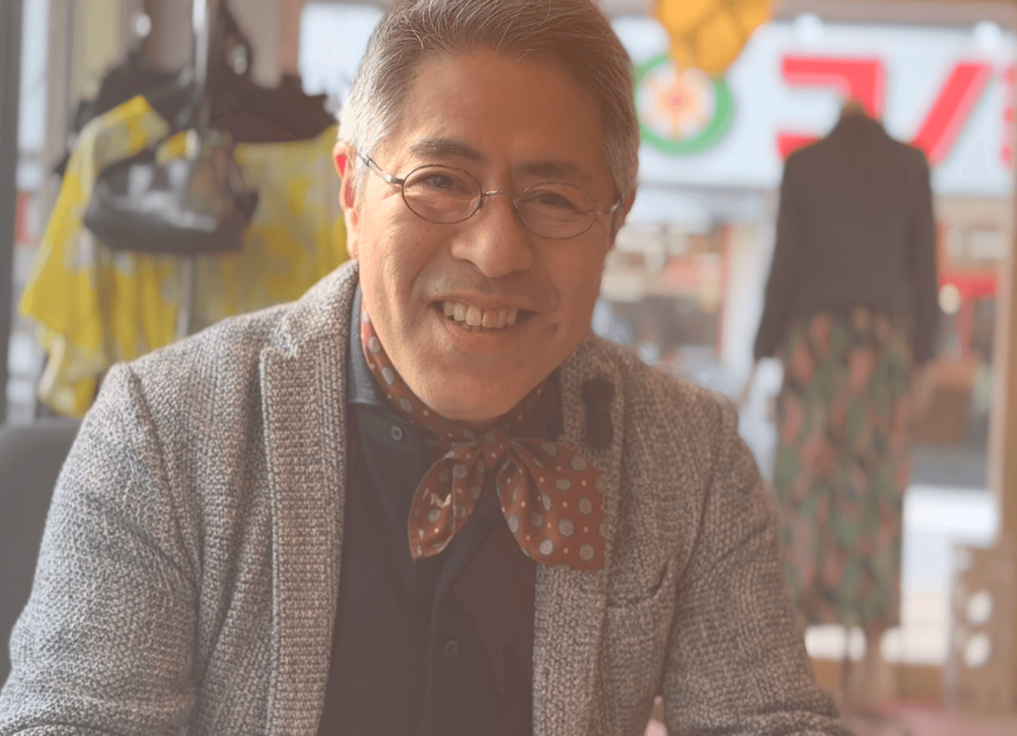 くらわんかファブリックを手掛ける富江さん。メガネと蝶ネクタイ、ストールを身につけ笑顔で迎えてくれる様子