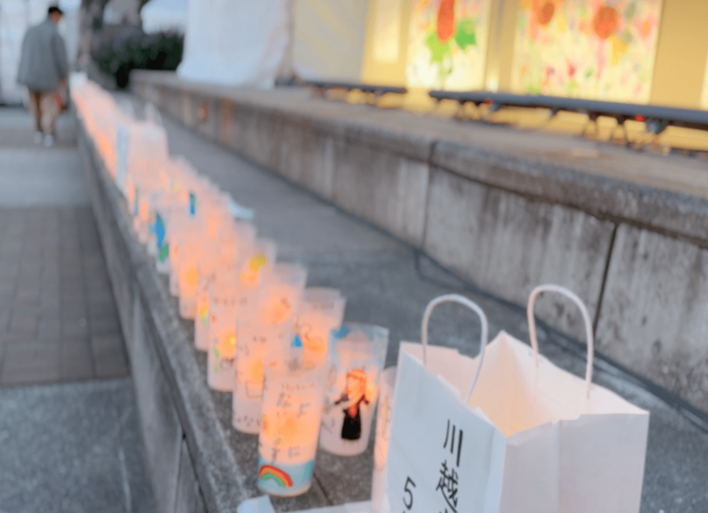 ニッペパーク岡東中央の石段に並べられた、子どもたちの平和のメッセージやイラストが描かれたキャンドル