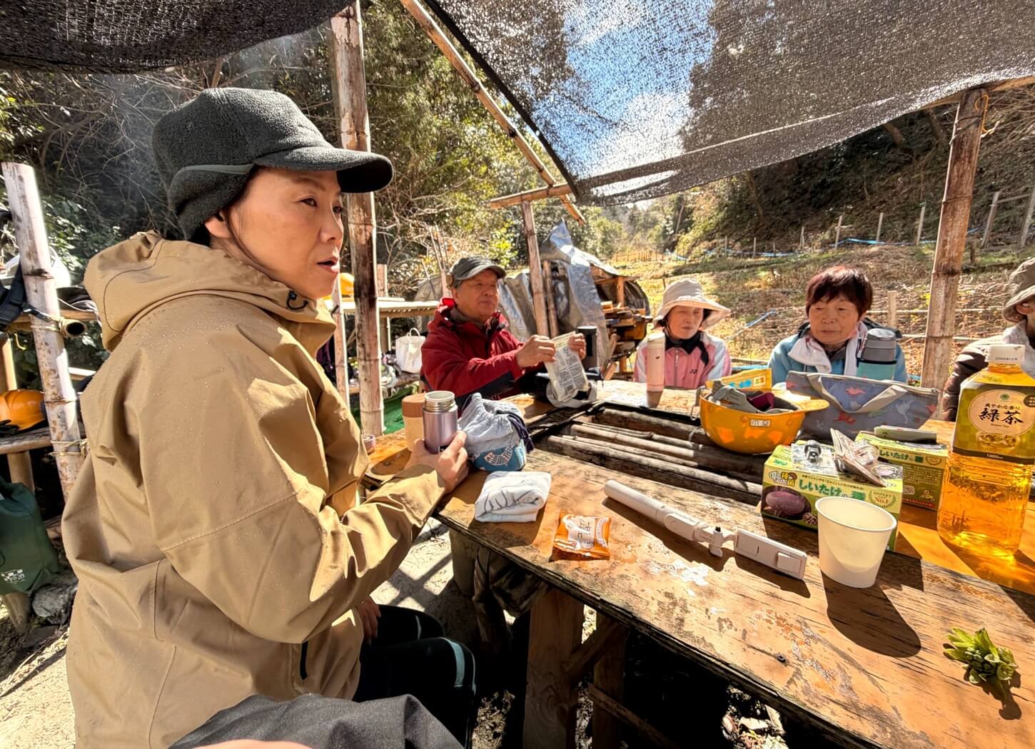 穂谷の里山で会員たちが食事を囲み、会話を楽しむ様子