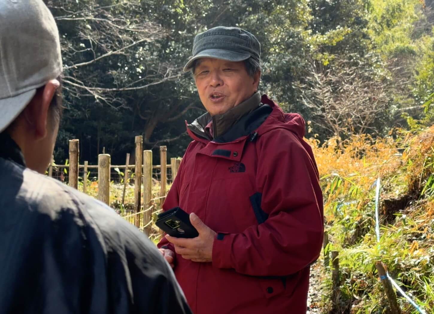 穂谷の里山で、見学者に説明をする石野さん